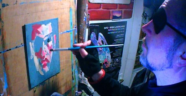 Rod tests painting a self portrait on a small scale with one eye.