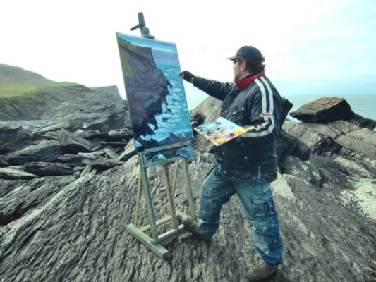 Perched on the edge of the world, Rod Coyne paints on Valentia Island, Co. Kerry.