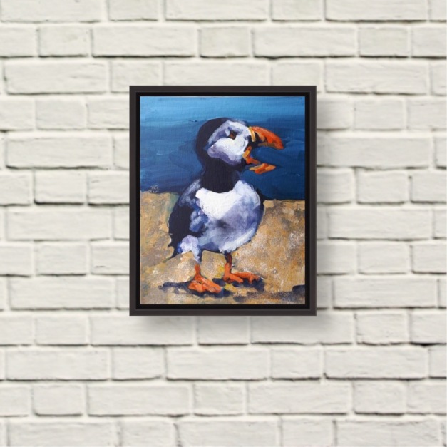 Image of "Preaching Puffin" a painting by Rod Coyne, framed original hung on a rough brick white wall.